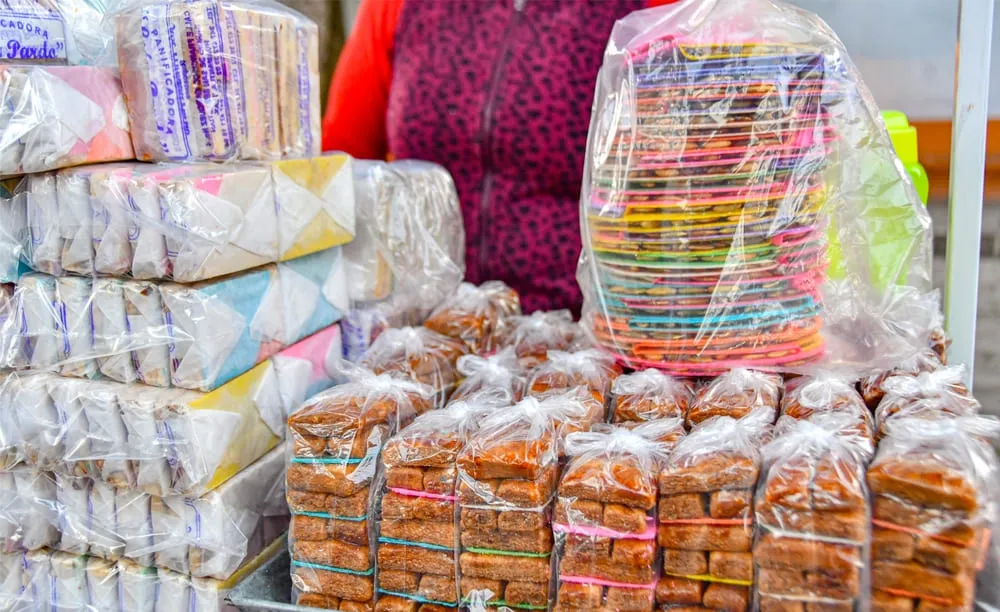 Muéganos de Huamantla empapelados y empaquetados para su venta, con otros dulces tradicionales al fondo