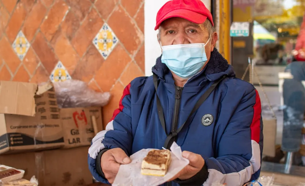 Artesano ofreciendo una muestra de muégano de Huamantla en su puesto de venta