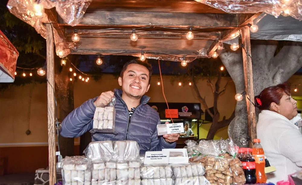 Productor de muéganos de Huamantla atendiendo su puesto y mostrando este dulce tradicional